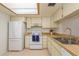 Cozy kitchen featuring white appliances, neutral cabinets, and butcher block countertops at 2650 Countryside Blvd # C204, Clearwater, FL 33761
