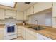 Cozy kitchen showcasing white appliances, butcher block countertops, and ample cabinet space at 2650 Countryside Blvd # C204, Clearwater, FL 33761