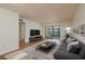 Bright living room with a sliding glass door to a balcony and wood-look flooring throughout at 2650 Countryside Blvd # C204, Clearwater, FL 33761