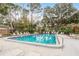 Sparkling community pool surrounded by comfortable lounge chairs and shaded by mature trees for relaxing outdoor enjoyment at 2650 Countryside Blvd # C204, Clearwater, FL 33761