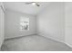 Bright bedroom with neutral carpet, ceiling fan, and a sunlit window with serene outdoor view at 27563 Pleasure Ride Loop, Wesley Chapel, FL 33544