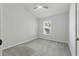 Minimalist bedroom with neutral carpet, ceiling fan, and a sunlit window with serene outdoor view at 27563 Pleasure Ride Loop, Wesley Chapel, FL 33544