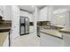 Bright kitchen with white cabinets, modern appliances, and a neutral tiled backsplash at 27563 Pleasure Ride Loop, Wesley Chapel, FL 33544