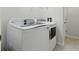 Modern laundry room featuring white GE Profile washer and dryer set with sleek controls and ample capacity at 27563 Pleasure Ride Loop, Wesley Chapel, FL 33544