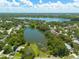 Expansive aerial view of the community, highlighting the serene lake and lush green surroundings at 2770 Steeple Ct, Palm Harbor, FL 34684