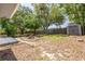 Large backyard with a fire pit, storage shed, and surrounded by mature trees at 2770 Steeple Ct, Palm Harbor, FL 34684