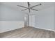 Light-filled bedroom features wood-look floors, large fan, fresh paint, and closet space at 2770 Steeple Ct, Palm Harbor, FL 34684