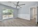 Bright bedroom with sliding glass doors to deck, wood-look floors, large ceiling fan, and bathroom access at 2770 Steeple Ct, Palm Harbor, FL 34684