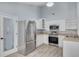 Well-lit kitchen with stainless steel appliances, white cabinetry, and a wine cellar door at 2770 Steeple Ct, Palm Harbor, FL 34684