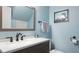 This bathroom features updated fixtures, a granite countertop and a framed mirror, complemented by light blue walls at 2941 Lichen Ln # B, Clearwater, FL 33760