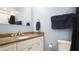 Bathroom with neutral granite countertop, large mirror and white cabinetry at 2941 Lichen Ln # B, Clearwater, FL 33760