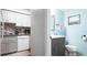 Updated bathroom shows a vanity with modern fixtures adjacent to a kitchen with white appliances and granite countertops at 2941 Lichen Ln # B, Clearwater, FL 33760
