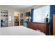 This bedroom has a dresser, shelving, a mounted TV, and an open closet for storage at 2941 Lichen Ln # B, Clearwater, FL 33760
