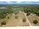 An aerial of the property shows the tree-lined community, the house, and pond in the distance at 31949 Amberlea Rd, Dade City, FL 33523