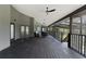Large, covered back porch features wood flooring and railings with views of the surrounding landscape at 31949 Amberlea Rd, Dade City, FL 33523