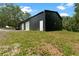 An exterior angle of the metallic building shows the door entrance and gravel near the property at 31949 Amberlea Rd, Dade City, FL 33523
