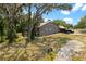 Exterior of home featuring a screened in porch, carport, and lush surrounding landscape at 31949 Amberlea Rd, Dade City, FL 33523
