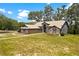 Beautiful brick home with mature trees, manicured lawn, and a walkway leading to the front entrance at 31949 Amberlea Rd, Dade City, FL 33523