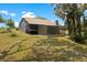 Rear view of the home features a screened in porch, fenced area, and mature trees for privacy at 31949 Amberlea Rd, Dade City, FL 33523