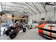 Spacious garage with an overhead loft, work benches and parking for a four-wheeler and sports car at 31949 Amberlea Rd, Dade City, FL 33523