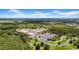 Aerial view featuring a school with athletic courts, surrounded by lush greenery, with ample parking at 32624 Summerglade Dr, Wesley Chapel, FL 33545