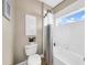 Cozy bathroom featuring neutral walls, a white toilet, tub/shower combo with a window, and stylish decor at 32624 Summerglade Dr, Wesley Chapel, FL 33545