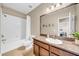 Bathroom featuring granite countertop, wooden vanity, large mirror, and tub with shower at 32624 Summerglade Dr, Wesley Chapel, FL 33545