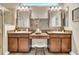Modern bathroom features dual sinks, tiled accents, a glass shower, and wood-style floors at 32624 Summerglade Dr, Wesley Chapel, FL 33545