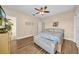 Well-lit bedroom with hardwood floors, ceiling fan, and a view at 32624 Summerglade Dr, Wesley Chapel, FL 33545