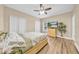 Bedroom with wood-look floors, ceiling fan, and backyard view at 32624 Summerglade Dr, Wesley Chapel, FL 33545