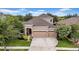 Charming two-story home with a three-car garage, beautiful landscaping and manicured lawn at 32624 Summerglade Dr, Wesley Chapel, FL 33545