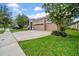 Well-maintained home with a two-car garage, green lawn, tidy landscaping and long driveway at 32624 Summerglade Dr, Wesley Chapel, FL 33545