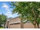 Charming home featuring a tan exterior, a two-car garage, and beautifully framed by a flowering tree at 32624 Summerglade Dr, Wesley Chapel, FL 33545