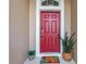 Close up of a red front door with sidelights, potted plant, and a welcome mat at 32624 Summerglade Dr, Wesley Chapel, FL 33545