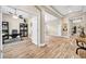 Hallway featuring an open doorway to an office and the continuation of wood-look tile flooring at 32624 Summerglade Dr, Wesley Chapel, FL 33545