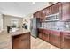 Modern kitchen featuring wood-style floors, dark cabinets, stainless steel appliances, and a center island at 32624 Summerglade Dr, Wesley Chapel, FL 33545