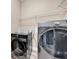 Modern laundry room with front loading washer and dryer plus wire shelving at 32624 Summerglade Dr, Wesley Chapel, FL 33545