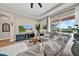 Spacious living room with a large gray sectional sofa and bright windows at 32624 Summerglade Dr, Wesley Chapel, FL 33545