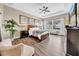 A cozy primary bedroom featuring tray ceilings, natural light, and wood-style flooring at 32624 Summerglade Dr, Wesley Chapel, FL 33545