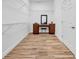 Spacious walk-in closet featuring custom shelving and a vanity area with elegant wood-look tile flooring at 32624 Summerglade Dr, Wesley Chapel, FL 33545