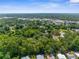 High-angle aerial view showing property's proximity to city amenities, set amidst lush greenery and mature trees at 3373 Olson Rd, Spring Hill, FL 34607