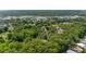 Aerial view captures the property's tranquil setting near commercial areas, nestled amidst mature trees and greenery at 3373 Olson Rd, Spring Hill, FL 34607