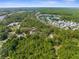 Aerial shot featuring the property's location near a peaceful lake and neighborhood surrounded by lush greenery at 3373 Olson Rd, Spring Hill, FL 34607