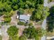 Aerial view of home showcasing lush greenery, sheds, and road access at 3373 Olson Rd, Spring Hill, FL 34607