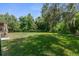 Expansive backyard with lush greenery and a screened-in porch at 3373 Olson Rd, Spring Hill, FL 34607