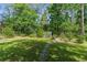 Large backyard with green grass, trees, and fence, offering ample space for outdoor activities at 3373 Olson Rd, Spring Hill, FL 34607