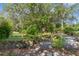Lush backyard featuring a serene pond with aquatic plants, surrounded by stone edging and paving stones at 3373 Olson Rd, Spring Hill, FL 34607