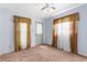 Cozy bedroom with carpet, ceiling fan, two windows with drapes, and light blue painted walls at 3373 Olson Rd, Spring Hill, FL 34607