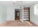 Bedroom with a view of a room, a ceiling fan, carpet, light-green walls, and wooden shelves at 3373 Olson Rd, Spring Hill, FL 34607