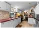 Functional kitchen with white cabinets, black appliances, and red countertops at 3373 Olson Rd, Spring Hill, FL 34607
